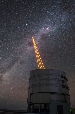 Four units of TOPTICA’s laser guide star system “SodiumStar 20/2” project powerful orange beams into the air in Chile’s Atacama desert at the VLT. (Credit: ESO/F. Kamphues)